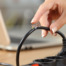 Close up of a woman hand holding a dangerous damaged electrical cord.