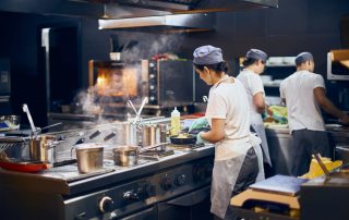 The team of cooks backs in the work in the modern kitchen.